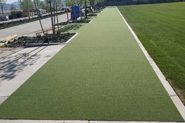 Flagstaff Outdoor tee line consisting of one continuous green synthetic grass strip surrounded by trees